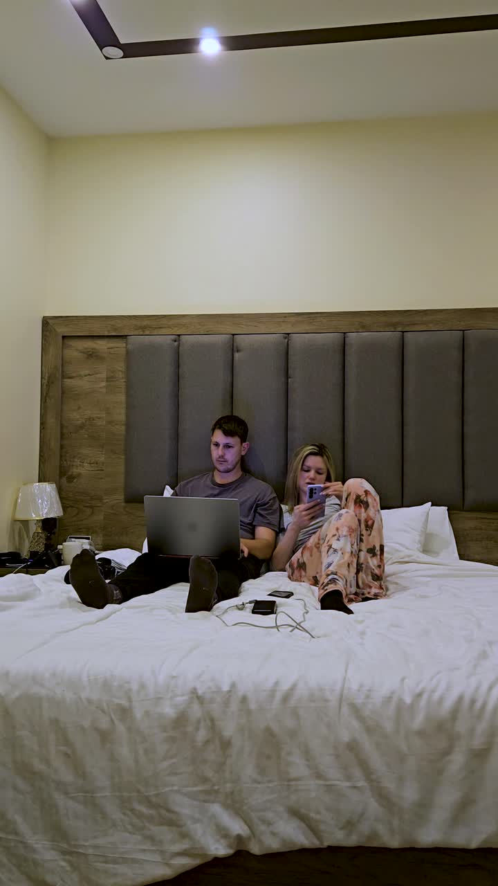 Pareja viajera trabajando de forma remota desde el dormitorio en timelapse