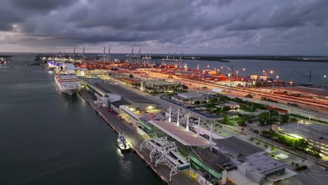 puerto industrial y público de miami con grúas y contenedores al anochecer