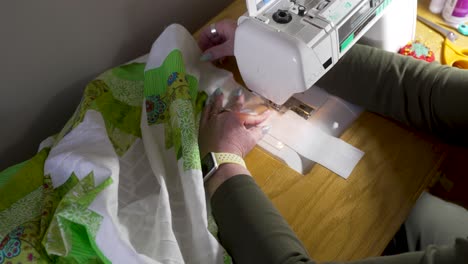 using a sewing machine to attach the border around the edge of the joined quilt blocks