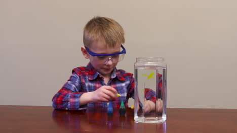 un niño mezclando colores para un experimento científico.
