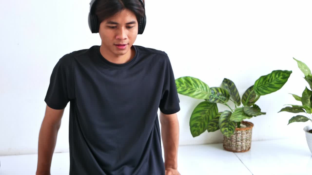 Man with headphones working out indoors with plants