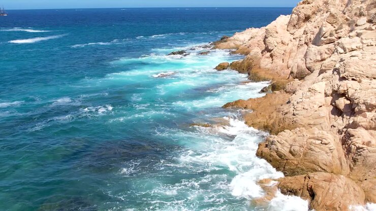 Ripresa aerea con drone di onde che si infrangono sulle scogliere marine a Cabo San Lucas, Messico