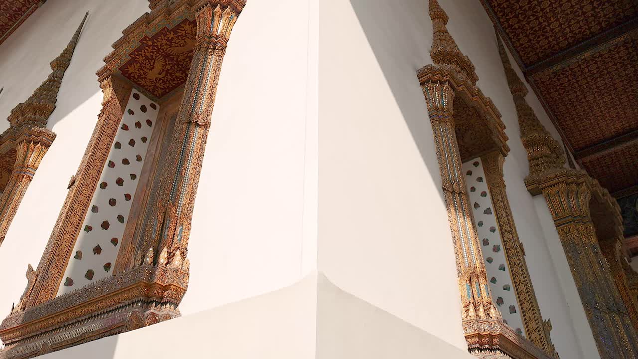 A detailed view of Wat Pho's ornate architecture in Bangkok, showcasing intricate carvings and vibrant colors under natural lighting