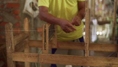 preparing a wooden old mechanical machine for weaving silk cotton