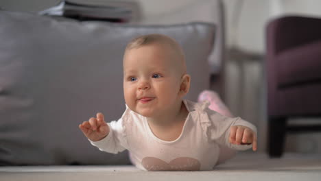 Baby-girl-on-her-tummy-playing-on-the-floor