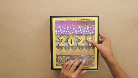 pegando números dorados en la portada del año 2021 archivo de arco de palanca del libro de recortes