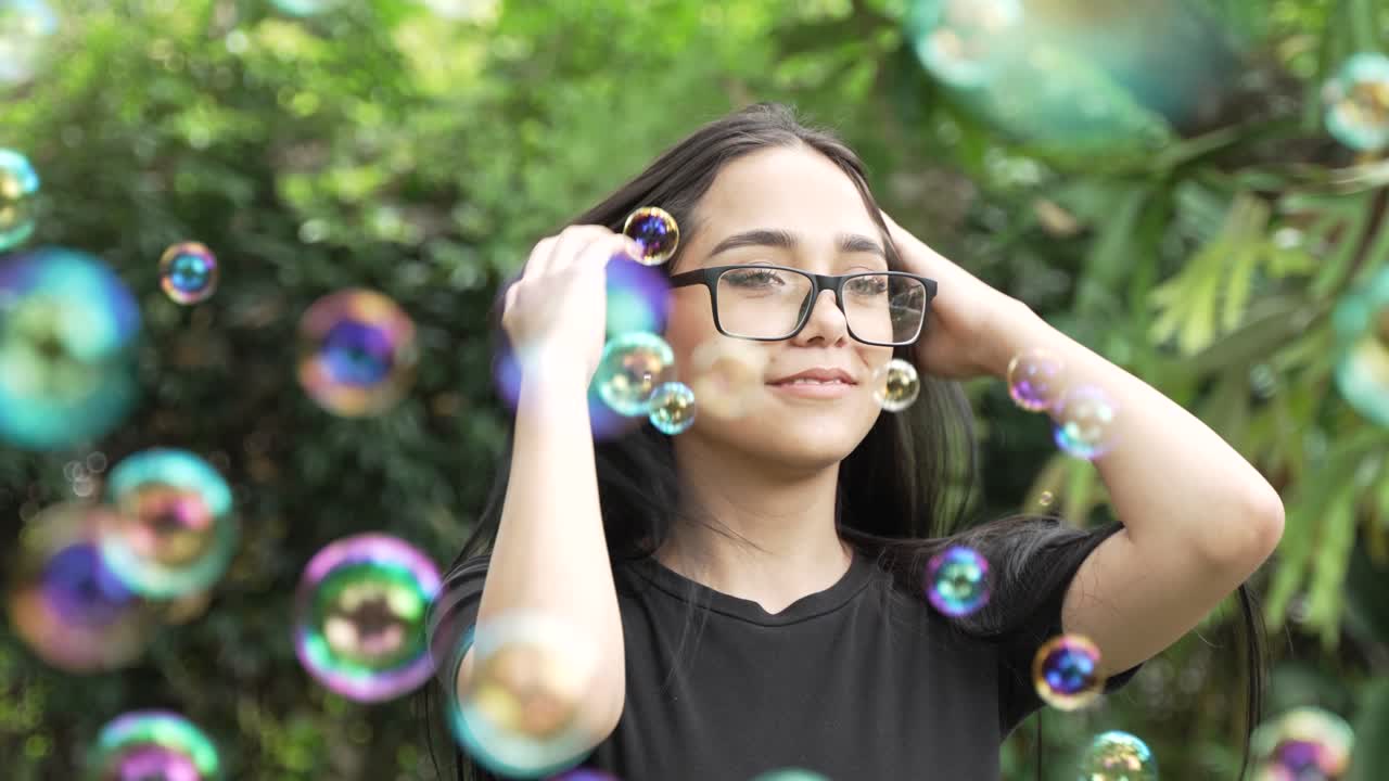 clip de cámara lenta de hermosa mujer latina de ojos verdes riéndose detrás de escena de una sesión de fotos con burbujas