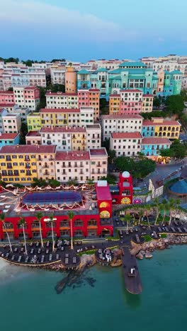 vertical zoom-out drone shot of sunset town panoramic view during sunset, a fake italian city in phu quoc island, vietnam.