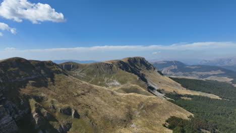 Flight-over-beautiful-mountain-peaks-covered-with-grass