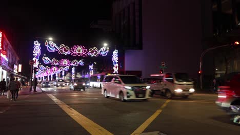 colorful festival lights illuminate busy singapore street at night