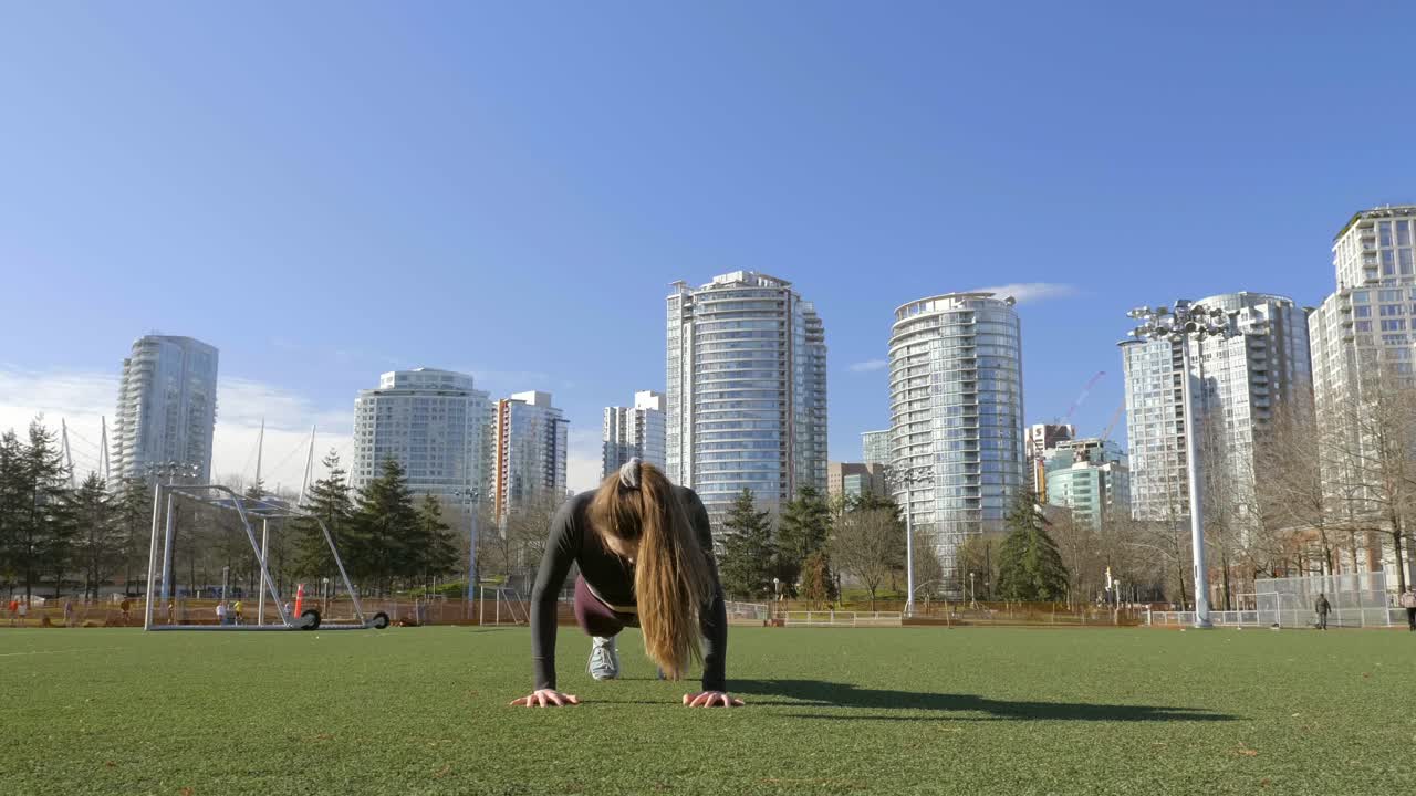 mujer joven haciendo ejercicio de burpees en tiro de cámara lenta del parque
