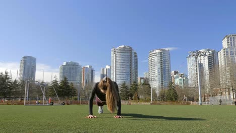 young woman doing burpees exercise in park slow motion shot