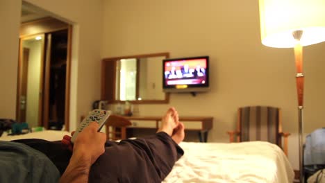 young man watching tv in hotels room 1