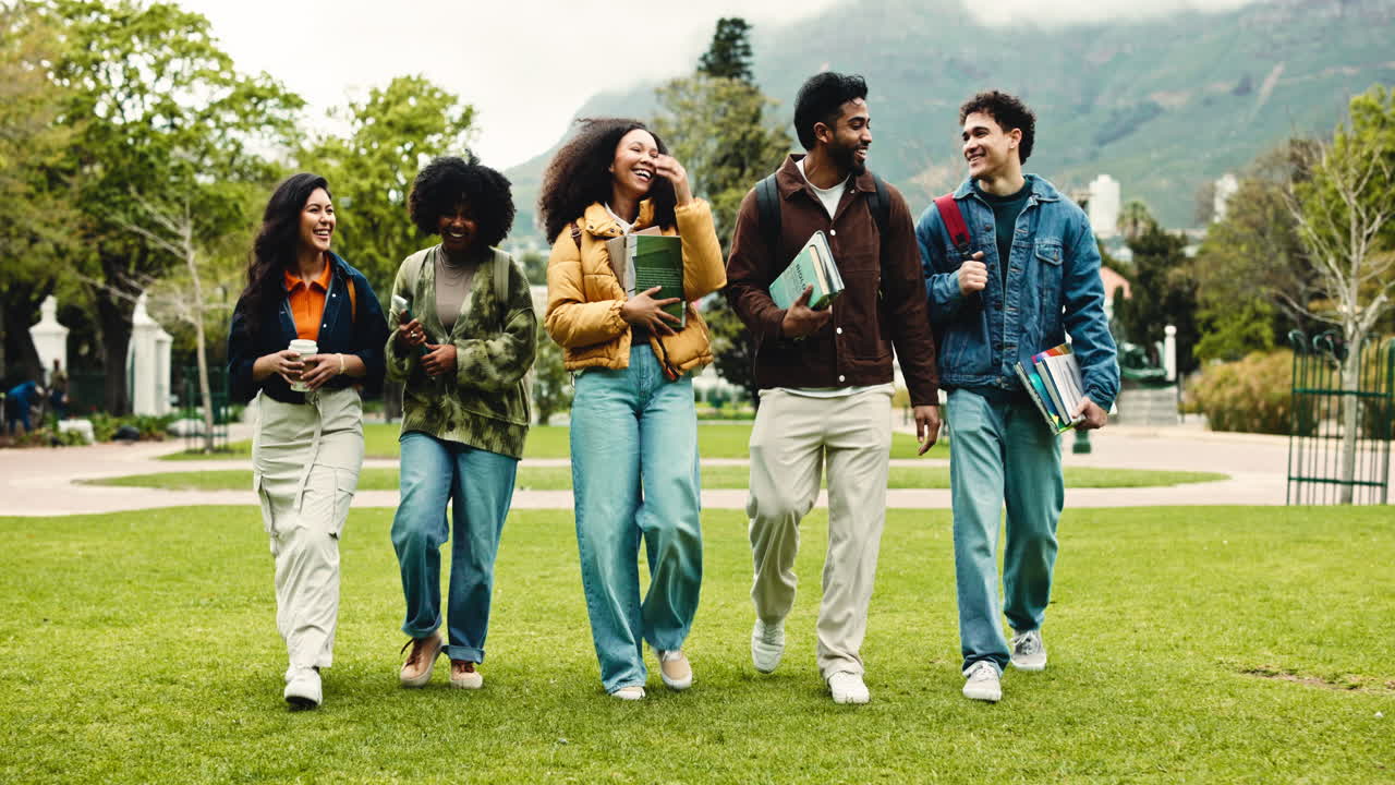 Gruppo diversificato di studenti felici che camminano e parlano nel campus universitario