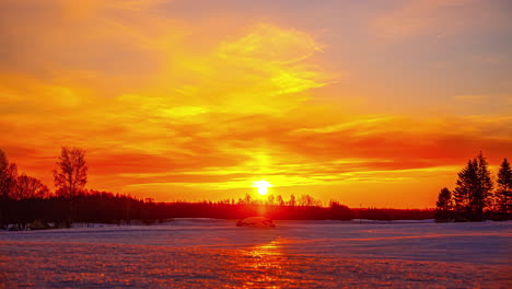 un hermoso amanecer rojo anaranjado sobre un paisaje cubierto de nieve
