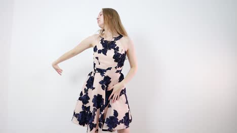 young woman in a floral dress posing against a white background