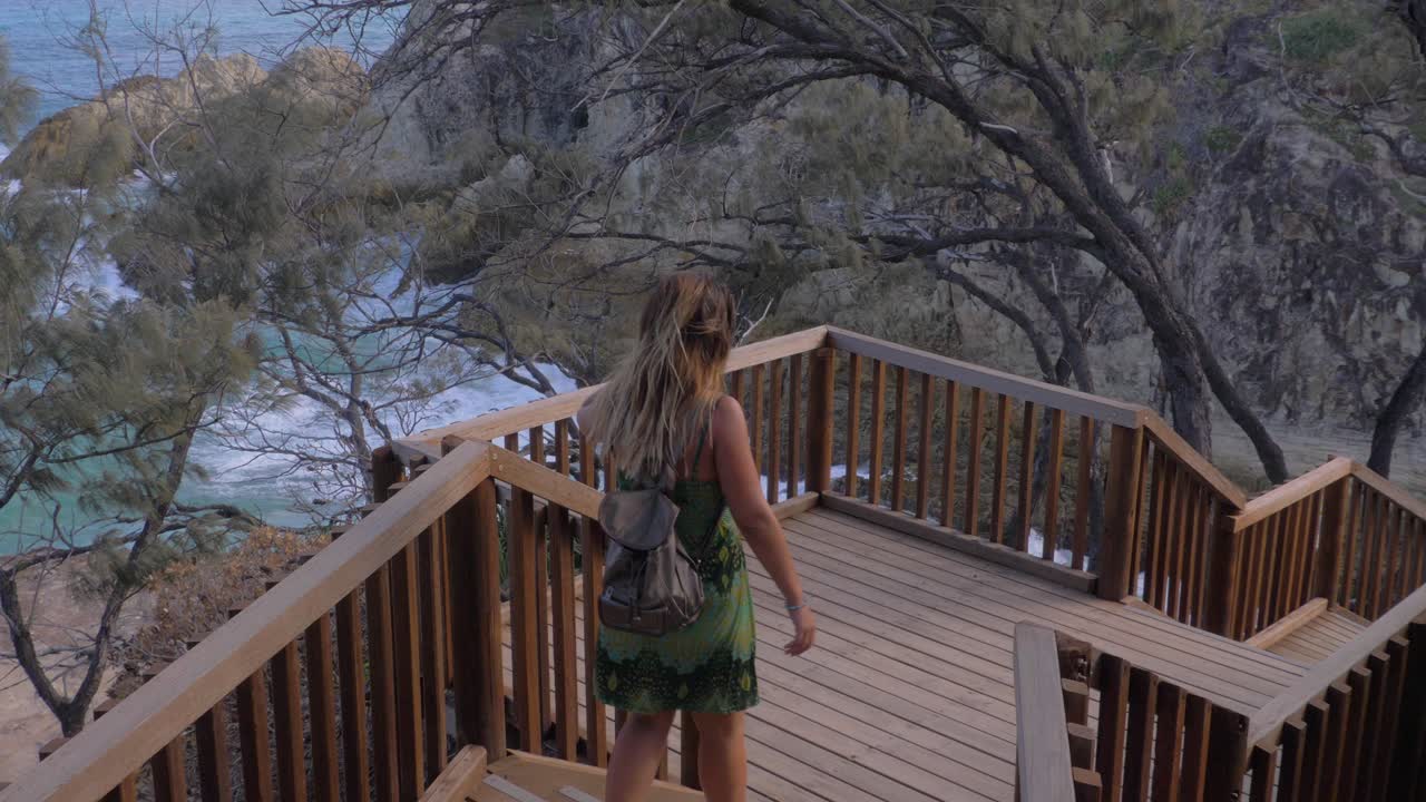 mujer con mochila bajando las escaleras en north gorge walk - point lookout, north stradbroke island, australia