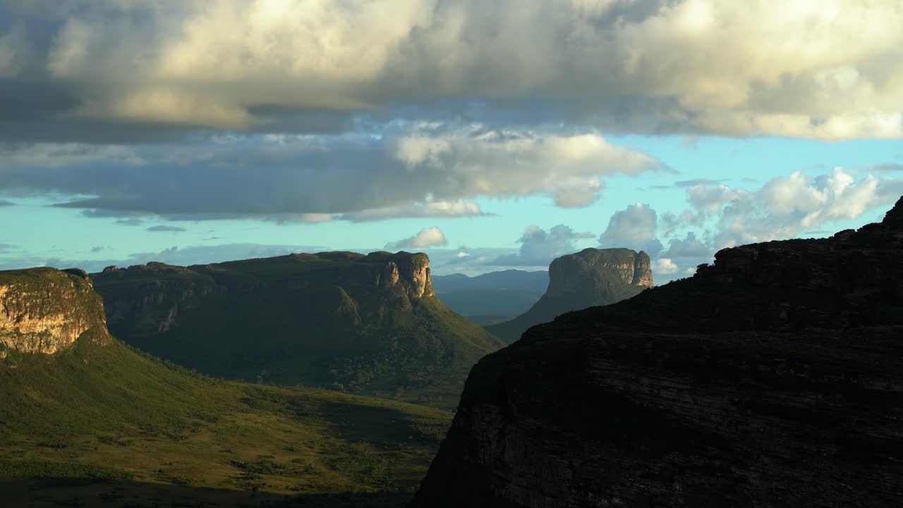 Tilting down shot revealing the stunning Capao Valley with large plateaus from the top of Mount of Pai Inácio in the Chapada Diamantina national park in northern Brazil on a warm summer evening