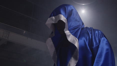 boxeador con guantes y túnica entrando en el ring antes del comienzo del partido de boxeo 1