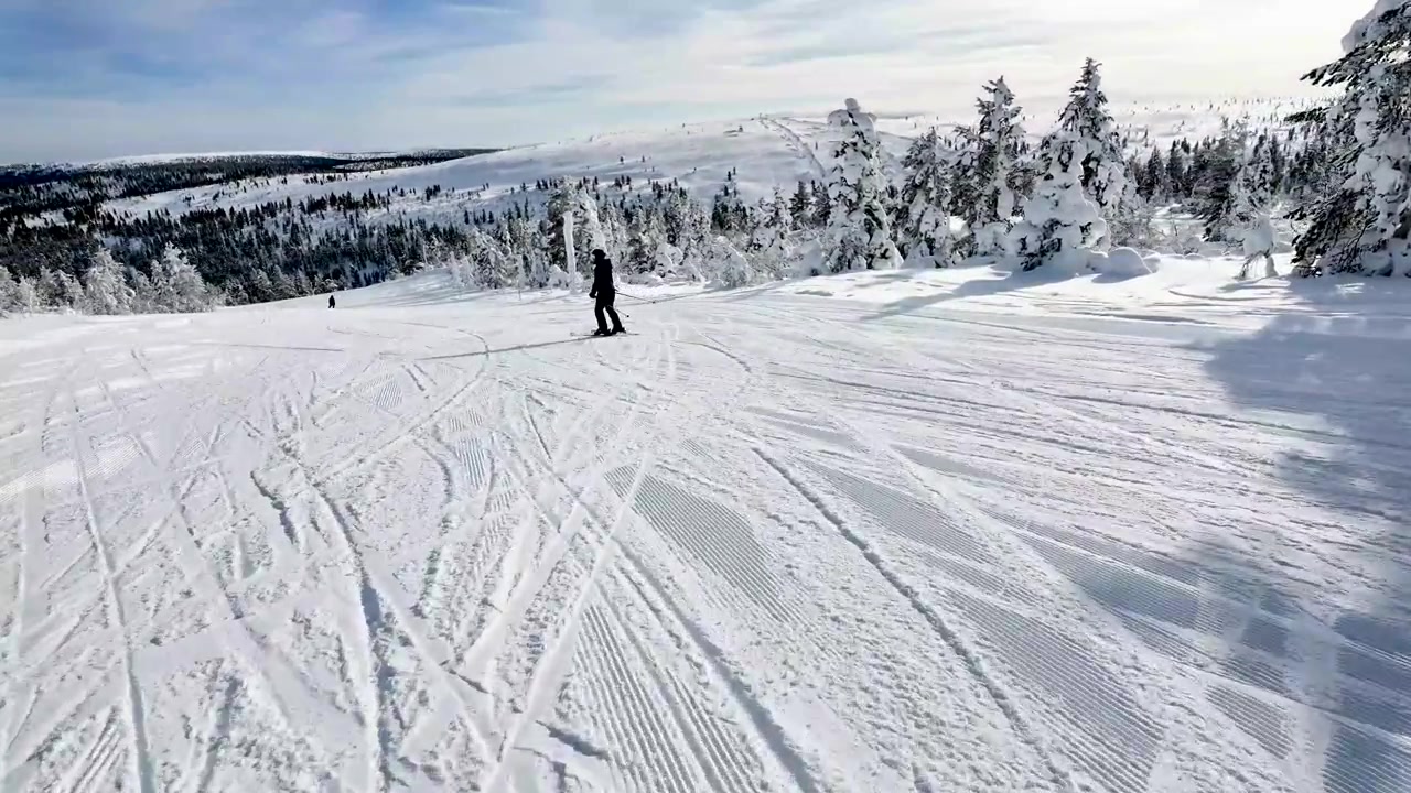 Sciatore su pendio montano in una stazione sciistica invernale