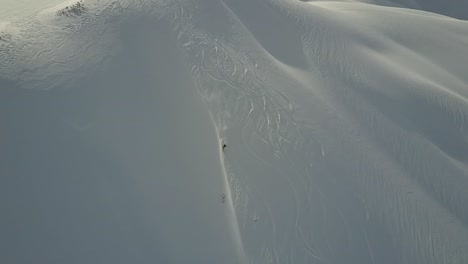 Telemarker-skiing-down-powder-slope-in-backcountry