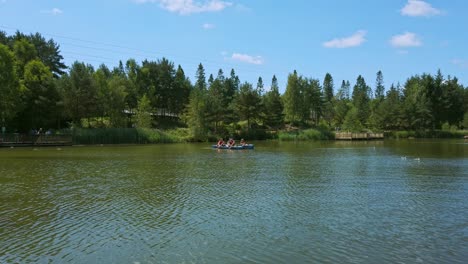 family kayak on lake in forest as zip liners descend in background