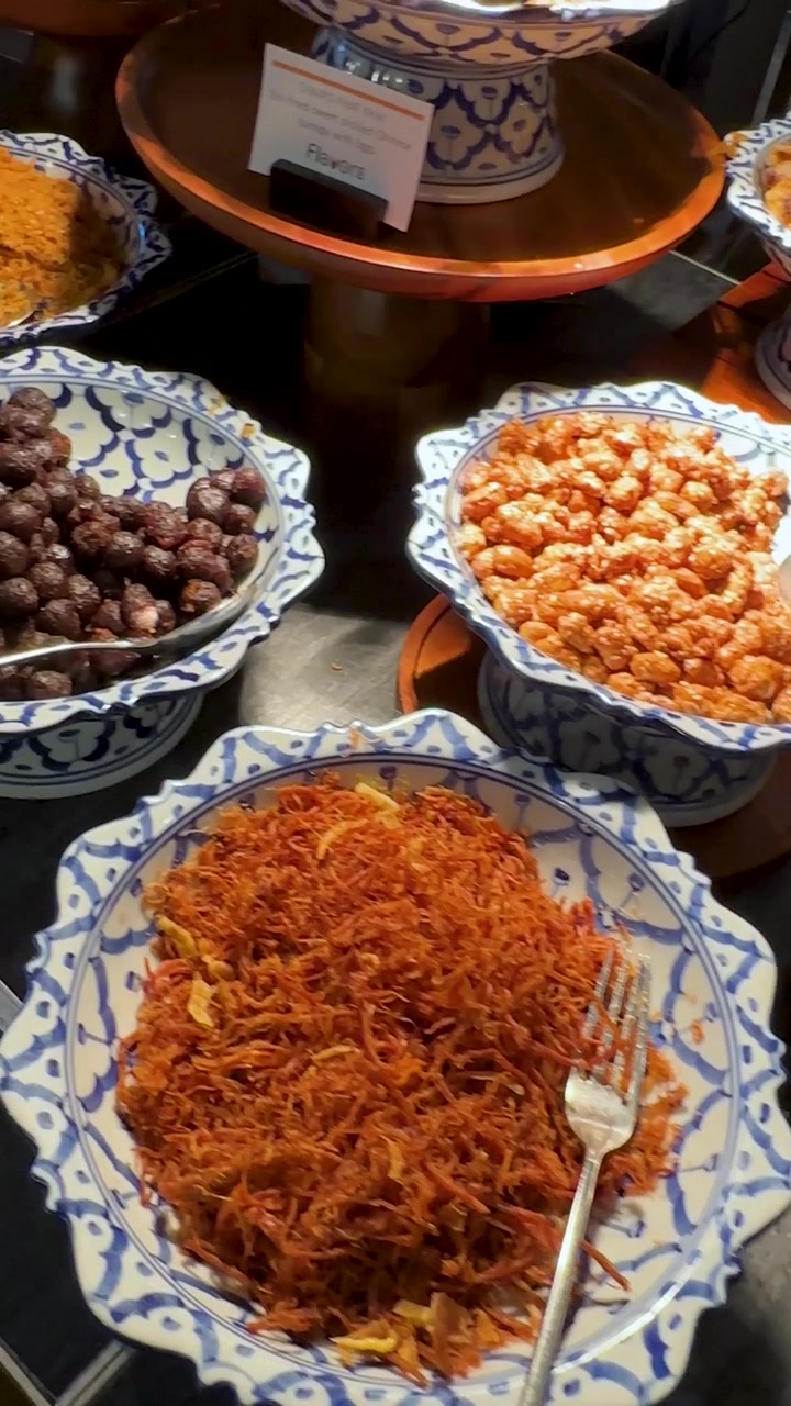 Pengambilan gambar panning sudut tinggi memperlihatkan lauk pauk tradisional Thailand dan air beraroma melati yang disiapkan untuk Khao Chae.