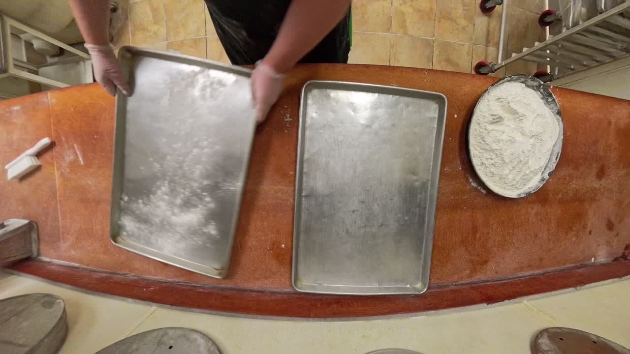 Worker dusts sheets for bread making