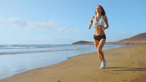 Silueta-De-Atleta-Femenina-Corriendo-En-La-Playa-Corriendo-Olas-Rompiendo-En-El-Fondo-De-La-Mañana-Junto-Al-Mar.-Steadicam-En-Cámara-Lenta.