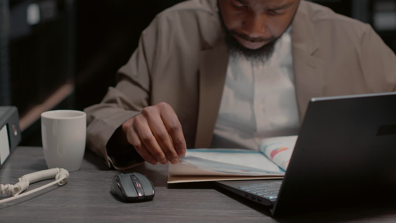 Man working at desk with laptop and documents