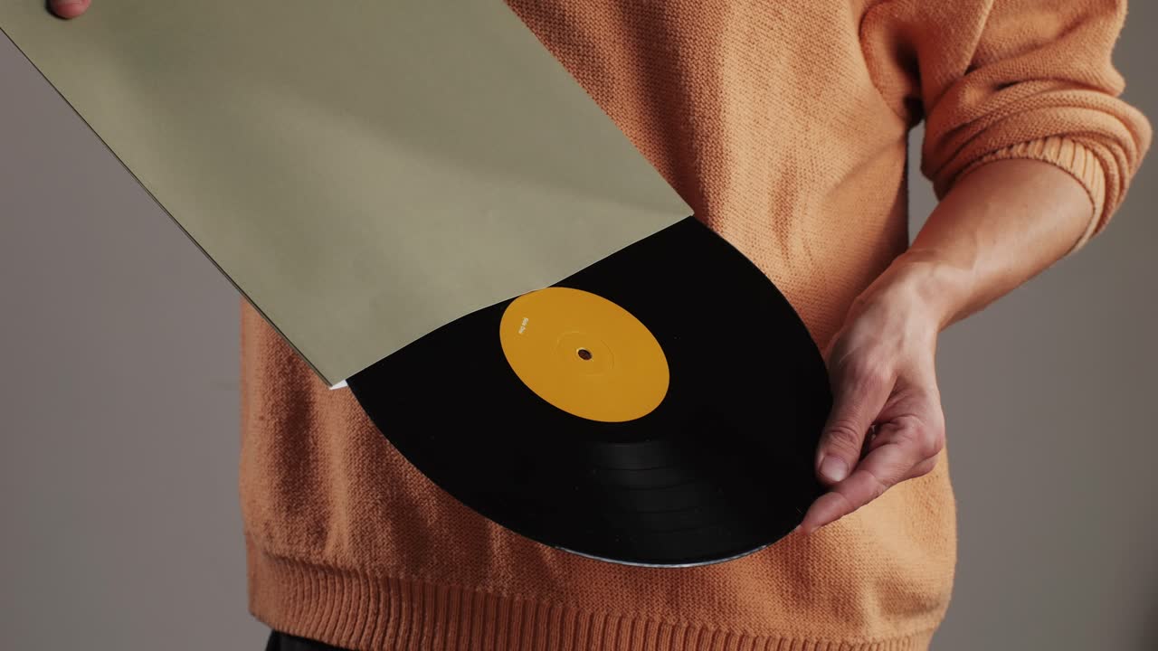 Retro Vinyl records in man hands close-up macro. Old disck for music. Retro vintage music player at home