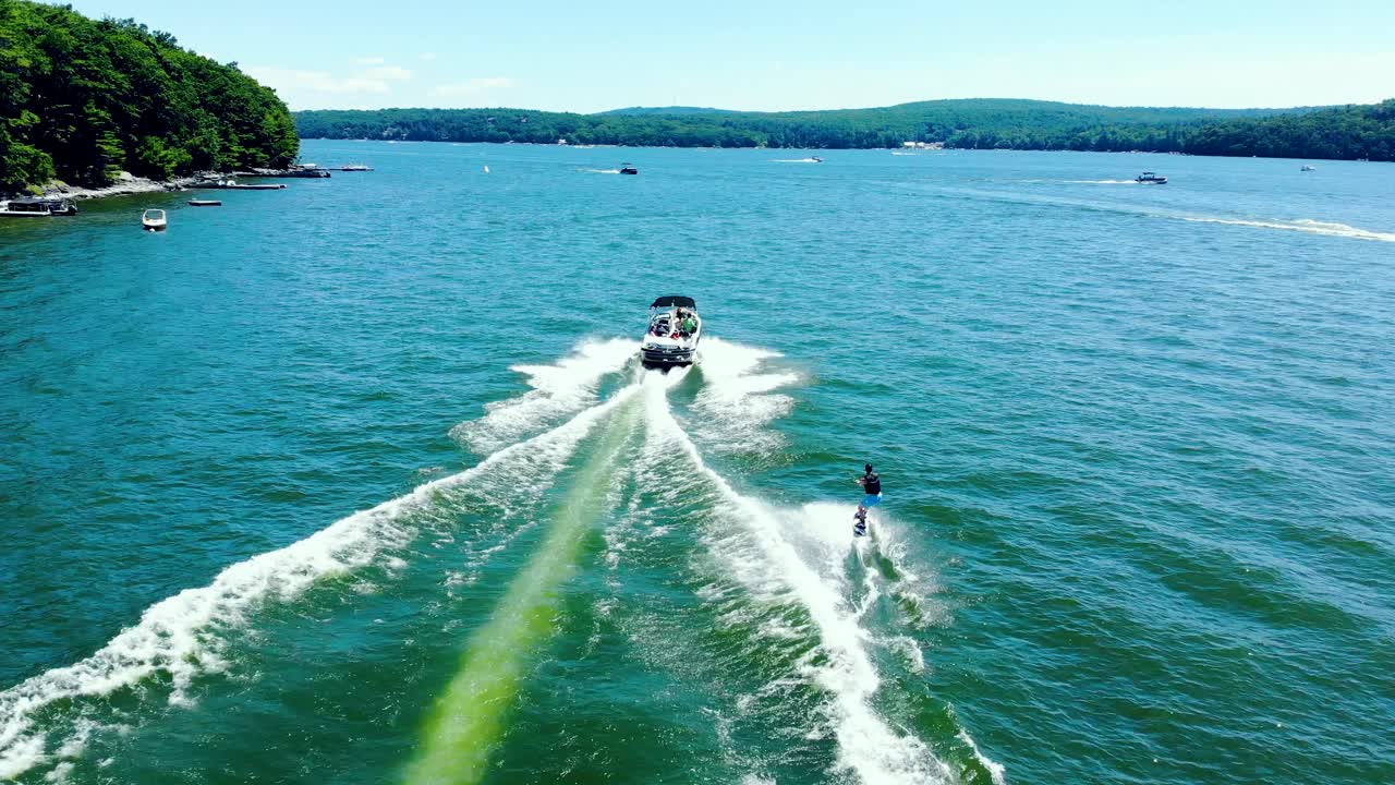 고속 모터 보트 뒤에 묶여 수상 스키를 즐기는 관광객