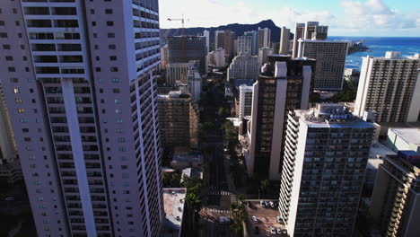 Cinematic-shot-flying-slowly-over-city-street-in-between-buildings-in-Honolulu-Hawaii