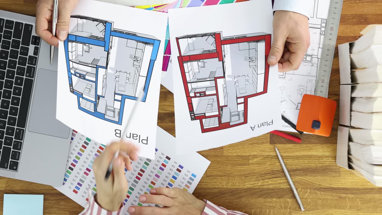 Architects or designers reviewing architectural floor plans on a desk