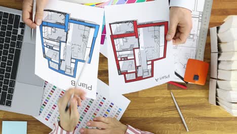architects or designers reviewing architectural floor plans on a desk