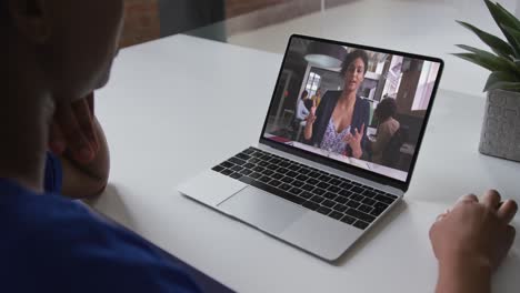 sección media de una mujer afroamericana haciendo una videollamada con una colega en una computadora portátil en la oficina