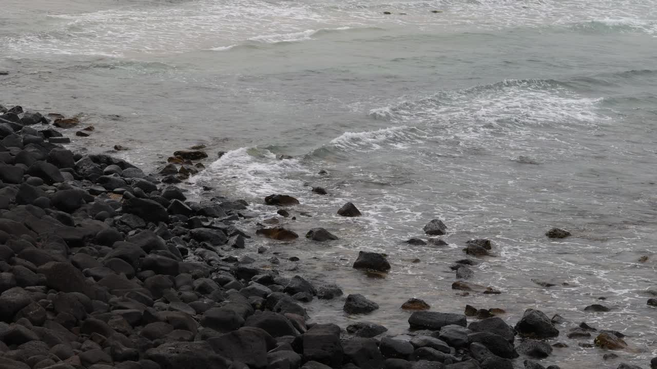 바다의 파도가 해변의 바위에 부히고