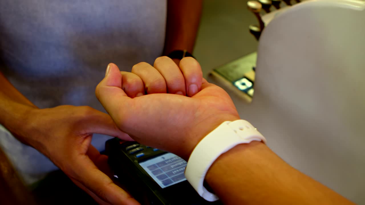 cliente masculino haciendo el pago a través de smartwatch 4k