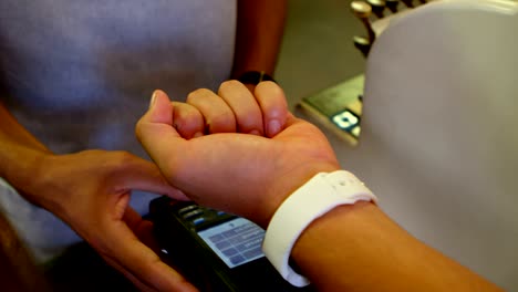 male customer making payment through smartwatch 4k