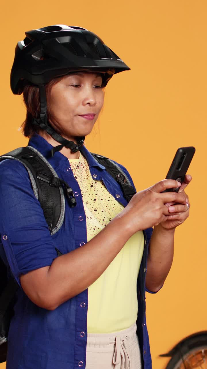 Asian woman with bicycle and smartphone