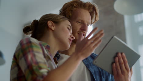 Smiling-couple-with-tablet-moving-hands-during-house-renovation-indoors.