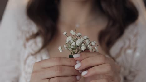 bride holding a small bouquet of white flowers