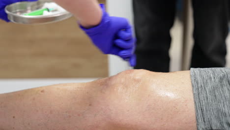 male knee is covered with antiseptic. patients is prepared for the prp therapy. close up.