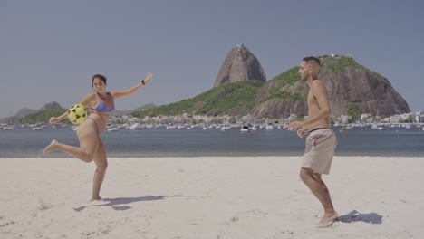 couple playing footvolley on a sunny beach in rio de janeiro