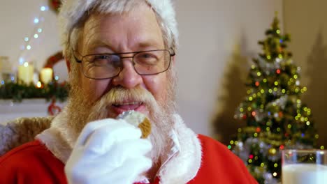 Papá-Noel-Relajándose-En-Una-Silla-Y-Comiendo-Comida-Dulce