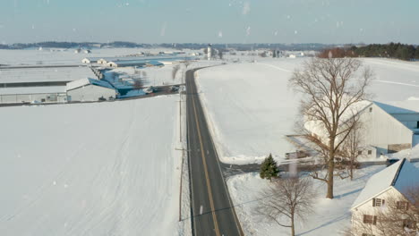 car on curvy road through rural winter snow landscape