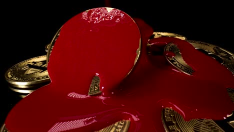 reverse pouring red paint over golden bitcoins on black background, symbolising the end of selling and return of crypto bull market