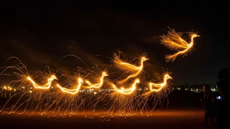a mesmerizing display of sparkling light as fiery birds take flight across a dark sky, capturing the essence of creativity and movement in a stunning nighttime scene