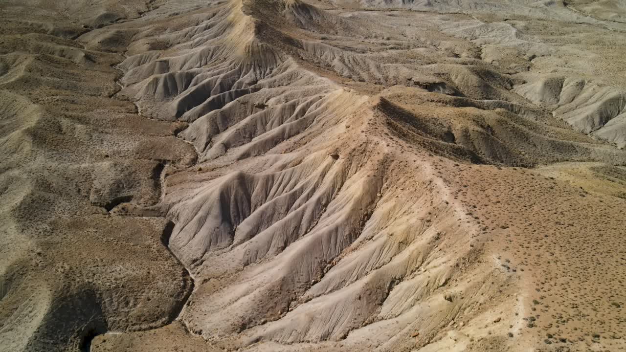 un espectacular drone de 4k filmado sobre las estériles colinas desérticas del área de grand valley ohv, con las empinadas mesetas de los acantilados de little book en la distancia, ubicado en grand junction, colorado