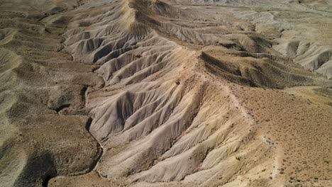 un espectacular drone de 4k filmado sobre las estériles colinas desérticas del área de grand valley ohv, con las empinadas mesetas de los acantilados de little book en la distancia, ubicado en grand junction, colorado